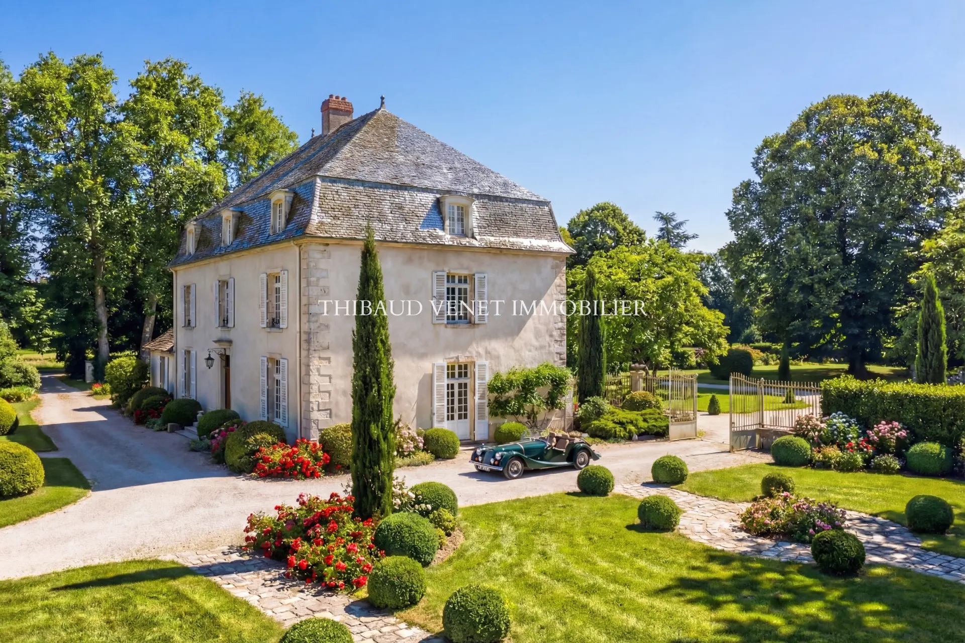 Maison de maître avec jardin paysager et voiture ancienne